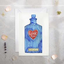 Load image into Gallery viewer, Blue potion bottle with a red heart label labeled 'Love Potion' on a white card.